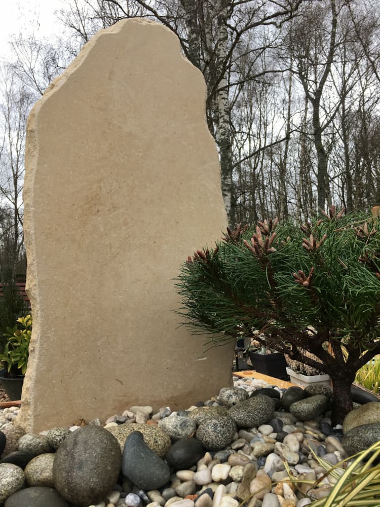 Une stèle en pierre retaillée irrégulièrement (ocre)